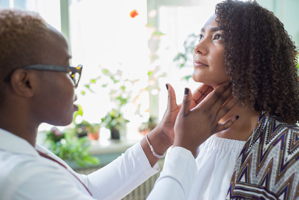 A doctor examining the neck of their patient.