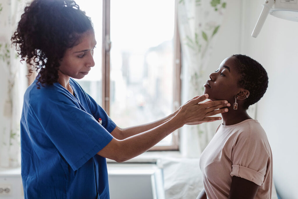 A nurse examining a patient's throat.